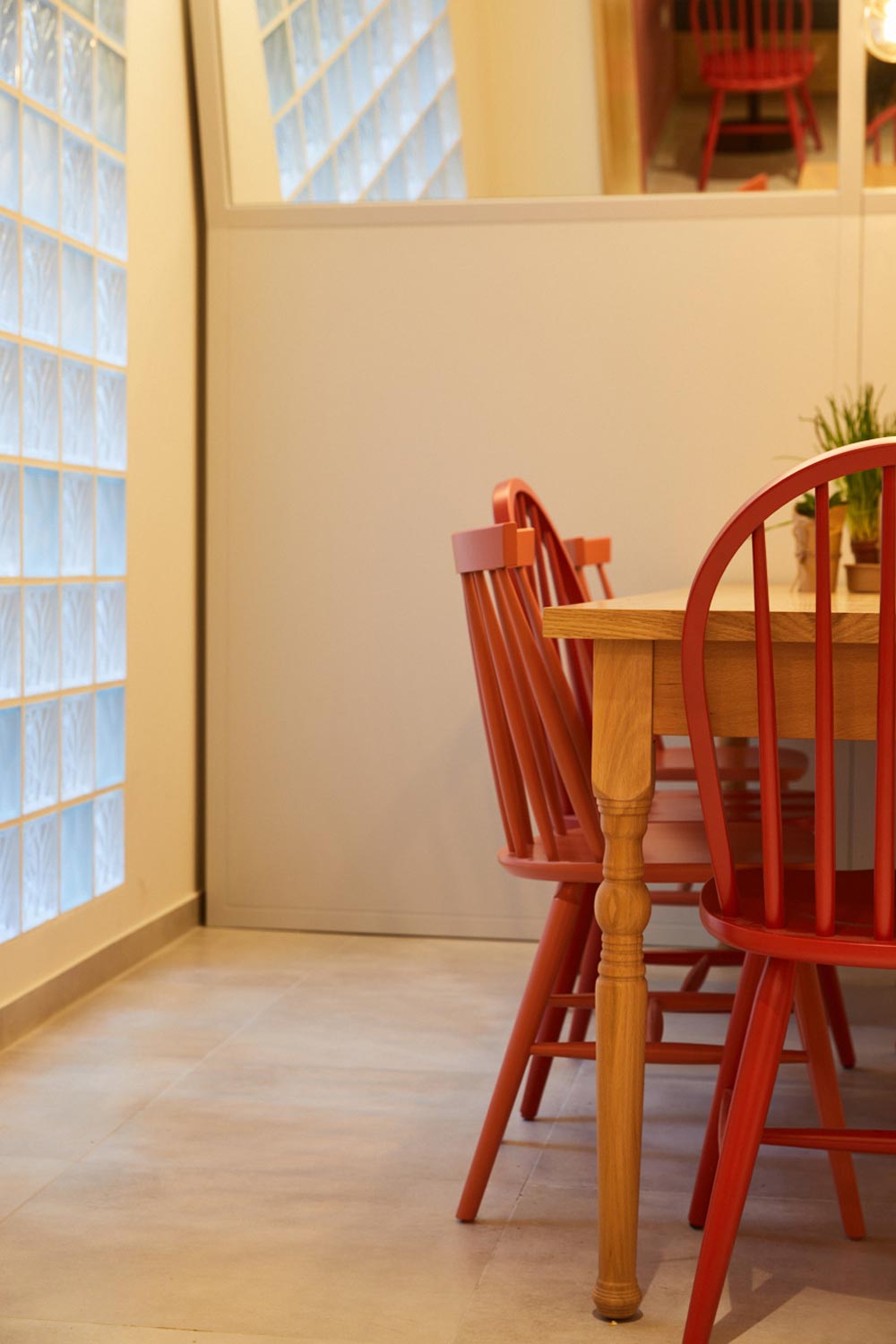 Brunch shop interior, close up view of the wooden dining table and the red chairs.