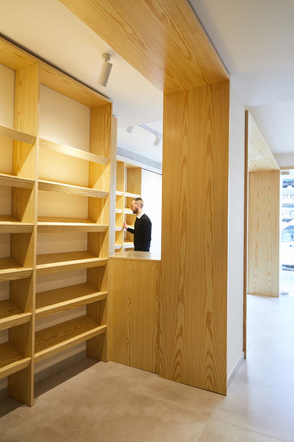 Brunch shop interior, view of the retail area with floor-to-ceiling wooden shelfs.