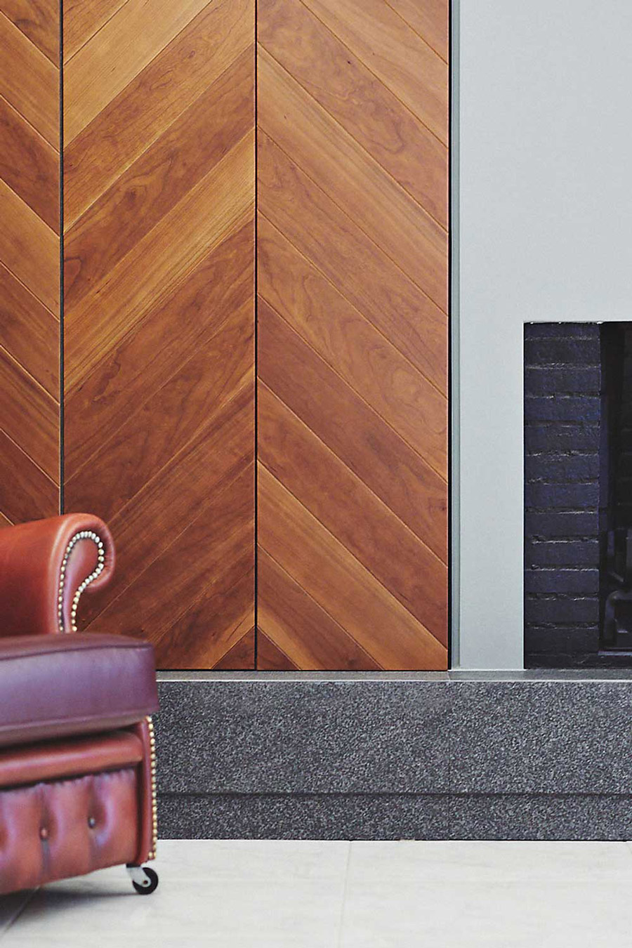 Cherry herringbone cupboards, minimal fireplace and black granite