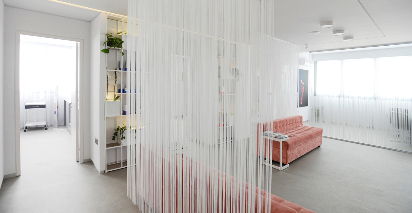 Medical interior design with light curtains and peachy velvet sofas. 