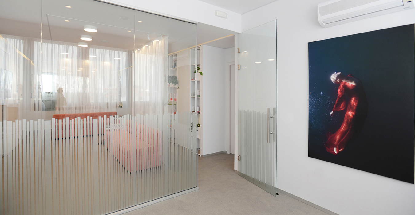 A large glass surface with sandblasted stripes is applied in the office space