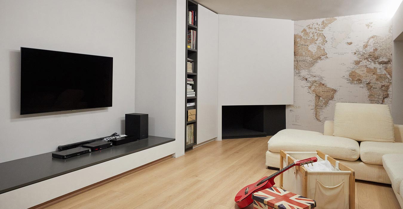 Fireplace structure with build in shelfs, marble bench and world map wallpaper.