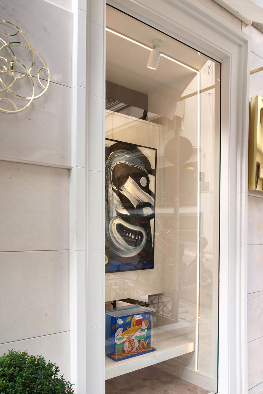 The light wooden partition functions as a double exhibition surface for paintings