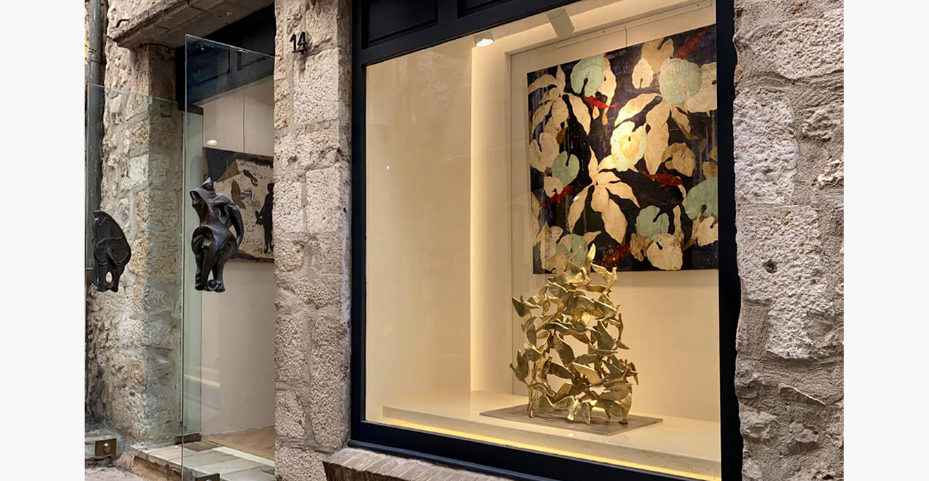 The glass doors have bronze sculptures as door handles.