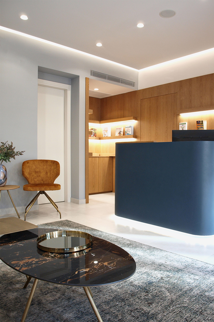 The bluish vintage rug matches with the blue reception desk