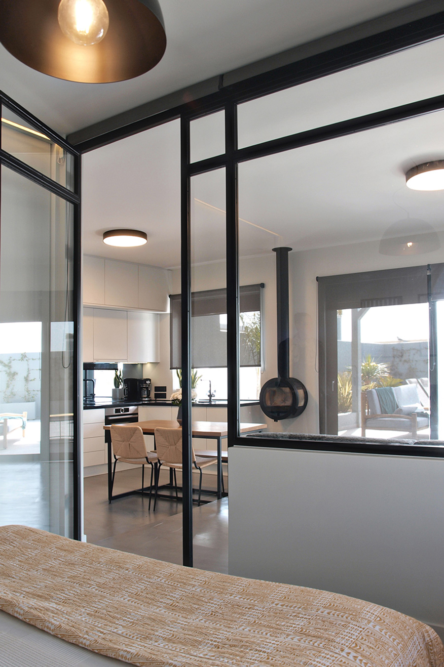 Modern glass partition between bedroom and open space kitchen.
